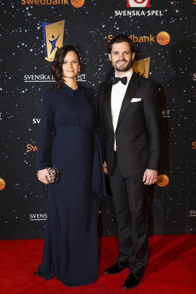 Putri Sofia tampil modest di karpet merah. Kali ini, perutnya yang kala itu tengah mengandung anak kedua terlihat di balik gaun biru ketatnya. Setelan klasik tuksedo tetap menjadi andalan Pangeran dalam acara formal. Foto: Dok. Getty Images