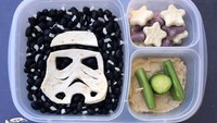 Masih tema Star Wars, kali ini Coffron mengangkat Stormtrooper. Dibuat dari tortilla, kacang hitam dan keju. Pelengkap sayuran dan hummusnya bikin bekal makin sehat. Foto: Instagram lunchboxdad