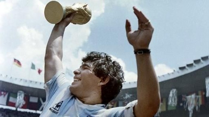Argentinas soccer star team captain Diego Maradona brandishes the World Soccer Cup won by his team after a 3-2 victory over West Germany on June 29, 1986 at the Azteca stadium in Mexico City. / AFP PHOTO / STAFF