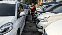 Seorang petugas membersihkan salah satu mobil rental di Jalan Tongkol, Tanjung Priok, Jakarta Utara, Selasa (5/6).