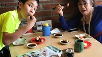 Seru ya melihat kekompakan Azka dan neneknya? Di restoran Jepang mereka nampak asyik ngemil sushi. Foto: Instagram: @azkacorbuzier