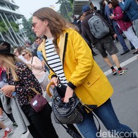 Udara sejuk di Roland Garros 2018 memungkinkan para fashionista pecinta tenis bereksperimen dengan outerwear. Wanita ini memasangkan jaket kuning bergaya jas hujannya dengan gaya kasual yang chic. Foto: Daniel Ngantung/Wolipop