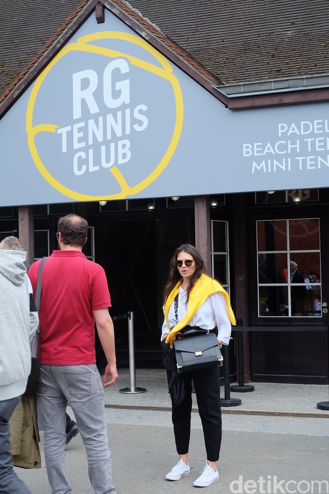 Sneakers putih menjadi alas kaki andalan hampir semua penikmat tenis perempuan di Roland Garros 2018. Wanita ini memberikan look yang berbeda pada Converse putihnya dengan padanan gaya monokrom dengan sentuhan warna kuning terang dari sweater-nya.  Foto: Daniel Ngantung/Wolipop