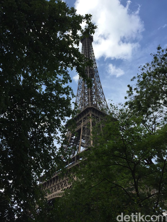 Menara Eiffel tetap photogenic saat difoto di sela-sela rimbunan pohon di taman sekitarnya. Saat ini, area bawah Menara Eiffel sedang melalui proses pemugaran sehingga tidak bisa dilewati pengunjung. Foto: Daniel Ngantung/Wolipop