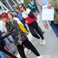 Sementara itu, penikmat tenis lainnya memilih jaket kamuflase transparan yang kontras dengan rambut merah dan tas kuningnya yang mencolok. Foto: Daniel Ngantung/Wolipop