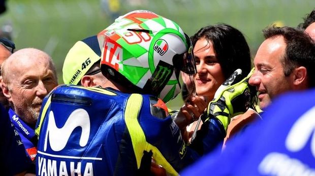 Italian Movistar Yamaha rider Valentino Rossi (back) kisses his girlfriend Francesca at the end of the Moto GP qualifying session of the Italian Grand Prix at the Mugello racetrack on June 2, 2018. / AFP PHOTO / TIZIANA FABI