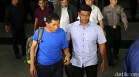 Orang kedua yang tiba di KPK mengenakan kaus oblong warna biru.