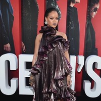 Rihanna tampil dramatis dengan busana berwarna gelap. Pilihannya jatuh pada gaun metalik aksen lipit Givenchy yang saling bertumpuk dan juga lipstik ungu. Foto: Ist.