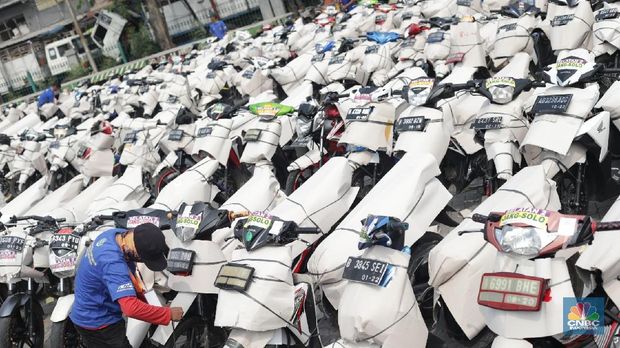 Petugas merapihkan kendaraan motor yang akan dibawa keluar kota di  Stasiun Barang Kampung Bandan, Jakarta Kamis (7/6). Kemenhub juga menggelar program pengiriman sepeda motor secara gratis untuk menurunkan angka kecelakaan pemudik yang menggunakan kendaraan roda dua. Persyaratan agar motor dapat dikirim secara gratis, pemudik harus menyiapkan data diri dan membawa KTP SIM, KK dan, STNK. Portrait pemudik, Diki 27 tahun sudah menggunakan jasa angkutan gratis dari Kemenhub. Menurut dia program ini sangat memudahkan warga untuk mudik. Ribuan motor tersebut akan dikirim besok pada 8 Juni 2018. (CNBC Indonesia/Muhammad Sabki)