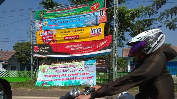 Spanduk 'Pendukung #2019GantiPresiden Anda sedang melewati jalan Tol Pak Jokowi'