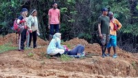 Di tengah jalan sang bidan tiba-tiba saja pingsan. Karena hari mulai gelap akhirnya tim membuat tandu darurat dan melanjutkan perjalanan. (Foto: Facebook/Amalia Usmaianti)