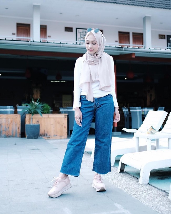Gaya Rifka bisa jadi inspirasi untuk wanita berhijab yang senang tampil kasual dan feminin. Seperti busananya ini, ia memadukan kaos putih panjang dengan kulot jeans. Hijab yang ia pakai yaitu hijab shawl berbahan sifon dengan warna dusty cream. Foto: Instagram Rifka Ayu