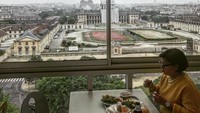 Nah ternyata ibunya lagi menikmati makanannya di Paris. Berlatar sebuah restoran di gedung bertingkat, Reggi Lawalata asyik menikmati makanan sambil memandang menara Eiffel. Keren! Foto: Instagram @lawalata13