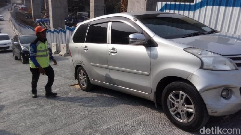 Petugas mengganjal mobil yang tidak kuat di tanjakan Jembatan Kali Kenteng, Susukan, Kabupaten Semarang Foto: Eko Susanto/detikcom Petugas mengganjal mobil yang tidak kuat di tanjakan Jembatan Kali Kenteng, Susukan, Kabupaten Semarang Foto: Eko Susanto/detikcom