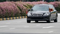 Sebuah mobil limusin besar dengan bendera Korea Utara beserta iring-iringan terlihat melaju melalui kota menuju Hotel St. Regis, tempat Presiden Cina, Xi Jinping, pernah menginap. Athit Perawongmetha/Reuters.