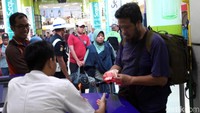 Petugas mengecek tiket milik calon penumpang.