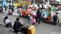 Banyak penumpang yang tidak mendapat tempat duduk di ruang tunggu memilih menunggu di pelataran parkir bis di Terminal Kampung Rambutan.