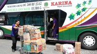 Beberapa petugas sedang mempersiapkan barang bawaan pemudik untuk ditempatkan di bagasi bus.