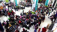 Mereka tampak duduk mengampar di stasiun karena tak kebagian kursi di ruang tunggu.