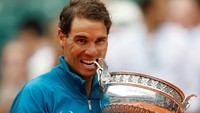 Trademark alias ciri khas Nadal yang menggigit trofi yang dijuarainya. Nadal memiliki rekor menang-kalah 86-2 di Prancis Terbuka. Dua kekalahan itu dari Robin Soderling di 2009 dan Novak Djokovic di 2016. (Foto: Charles Platiau/Reuters)