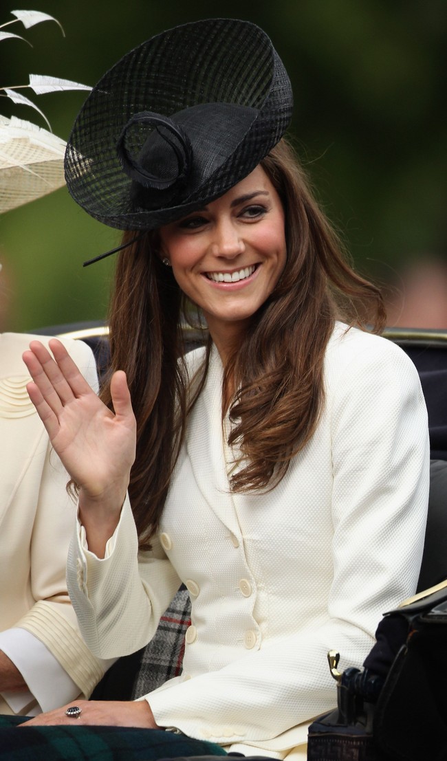 Ia memilih warna topi yang kontras dengan busana berwarna krem yang ia kenakan. Topi hitam dengan aksen jaring berbentuk unik itu merupakan karya Lock & Co. Foto: Getty Images