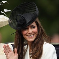 Ia memilih warna topi yang kontras dengan busana berwarna krem yang ia kenakan. Topi hitam dengan aksen jaring berbentuk unik itu merupakan karya Lock & Co. Foto: Getty Images