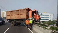 Truk sampah menabrak pembatas jalan Tol Wiyoto Wiyono di daerah Plumpang, Jakarta Utara. Kecelakaan ini membuat truk tersebut hampir terjatuh dari tol. (Foto: dok. TMC Polda Metro Jaya)
