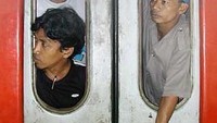 Pemudik berjejal di gerbong kereta ekonomi hingga di pintu kereta. Mereka mencari udara dengan melongokkan kepala keluar jendela yang pecah. Foto diambil di Stasiun Pasar Senen pada mudik 2003 silam.