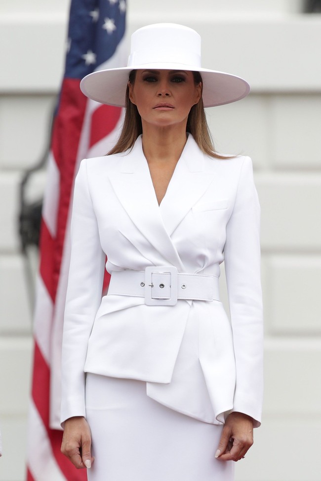 Melania Trump memakai setelan serba putih ketika menyambut pemimpin Prancis beberapa waktu lalu. Tambahan belt besar di pinggang membentuk aksen peplum asimetris pada jaketnya. Foto: Dok. Getty Images
