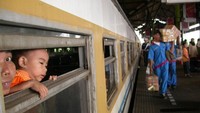 Pada Mudik 2005, kereta kelas bisnis belum diberi AC. Tampak seorang anak mencari udara segar di Stasiun Gambir.