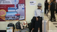 Penuhnya Terminal Pulo Gebang membuat beberapa pemudik tidak mendapat tempat duduk untuk menunggu bus datang. Sehingga mereka terpaksa menduduki barang bawaan yang dibawa untuk melepas lelah.