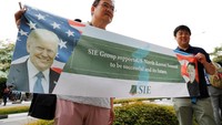 Ada pula warga yang membawa spanduk bergambar kedua tokoh dunia tersebut dengan tulisan yang berisikan harapan pertemuan tersebut bisa menjadi penanda baik untuk kehidupan dunia yang akan datang. Kim Kyung-hoon/Reuters.