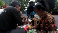 Penjual tengah membungkus parsel pesanan pembeli lengkap dengan kartu ucapan.