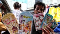 Seorang pedagang memamerkan aneka amplop yang dijualnya di depan kamera.