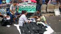 Hanya bermodalkan alas dari karung, PKL menjajakan dagangannya.