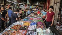 Sudah puas berbelanja pakaian dan aksesoris lainnya, maka selanjutnya yang menjadi sasaran warga Gaza adalah makanan ringan sebagai makanan untuk menjamu tamu dan sanak keluarga yang datang bersilaturahmi dari rumah ke rumah. Banyak makanan ringan ditawarkan di pasar ini. Anadolu Agency/Getty Images.