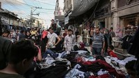 Salah satu kios yang paling banyak dikunjungi adalah kios pakaian. Banyak warga Gaza antusias memilih baju lebaran bersama keluarga. Anadolu Agency/Getty Images.