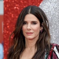 Sandra juga menyempurnakan gayanya dengan sepasang anting Lorraine Schwartz dan sandal-heels bergaya minimalis. (Foto: Tim P. Whitby/Getty Images)