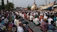 Jamaah menggelar sajadah di aspal.