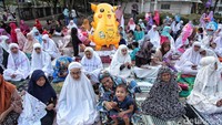 Seorang anak ikut salat dengan membawa balok pokemon.