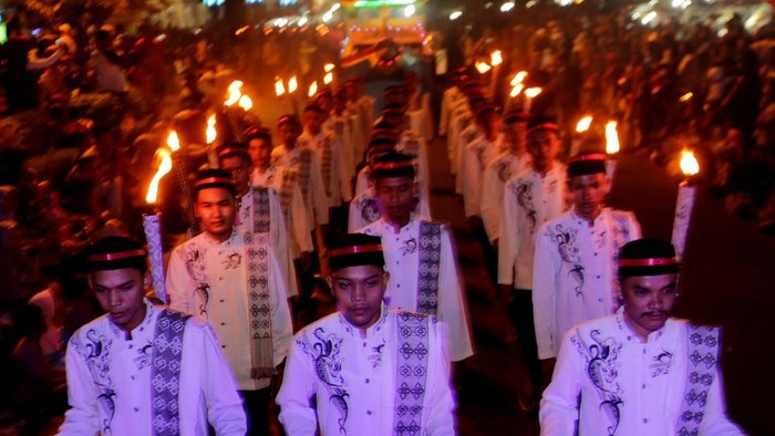 Peserta membawa obor sambil mengumandangkan bertakbir saat mengikuti pawai takbiran Idulfitri di Banda Aceh, Aceh, Kamis (14/6). Pawai takbiran yang diikuti ribuan warga dari dua kabupaten/kota dilaksanakan untuk menyambut Idulfitri 1 Syawal 1439 Hijriah. ANTARA FOTO/Irwansyah Putra/kye/18.
