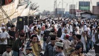 Salat digelar di antara kapal-kapal dan peti kemas.