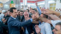 Assad saat menyalami pendukungnya di momen lebaran (Foto: Dok. SANA/Handout via REUTERS)
