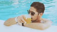 Penyanyi berusia 26 tahun ini, terlihat keren ketika menikmati segelas jus jeruk segar di dalam kolam renang. Wah, persis seperti model, ya? Foto: Instagram @petra_sihombing