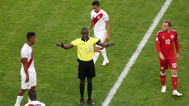 Wasit Bakary Papa Gassana menggunakan teknologi VAR dalam laga Peru melawan Denmark.