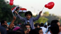 Anak-anak di Mesir terlihat cerita merayakan hari raya Idul Fitri. Balon dan bendera mewarnai perayaan Idul Fitri di negara asal Mohammad Salah tersebut (Foto: REUTERS/Mohamed Abd El Ghany)