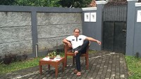 Duh, kalau orang-orang ngopi di teras. Pelawak ini justru memilih duduh santai di belakang pintu belakang rumahnya. Ada ada aja, ya. Foto: Instagram ajis_gagap22