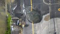 Lubang itu terbentuk tepat di tengah jalan. Kyodo/via REUTERS.