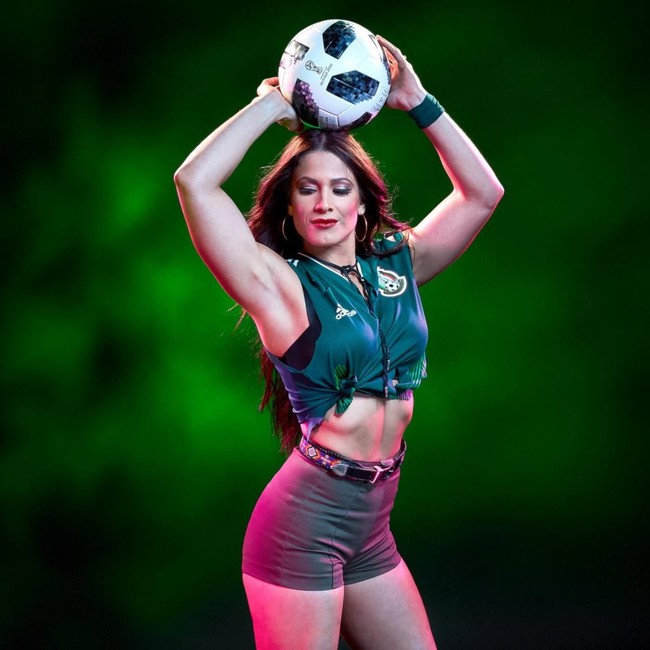 Pegulat cantik Dasha Fuentes berpose memamerkan perut langsingnya dan otot lengannya dengan memegang bola. Dalam acaraa Smack Down, Dasha dikenal sebagai presenter di belakang panggung. Foto: WWE