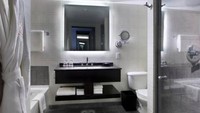 Di bagian kamar mandi terpasang wallpaper wallpaper berwarna keperakan, dipadu dengan ubin abu-abu batu tulis. Ada bak mandi dan pancuran terpisah. Telegraph/Istimewa.